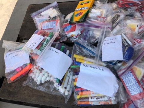 Dozens of clear zip bags packed with toothbrushes, toothpaste and school supplies.