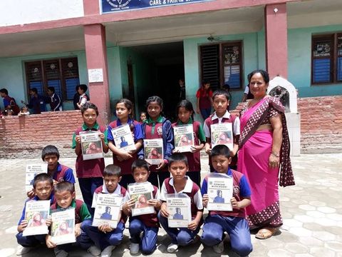 Students holding awards beside teachers in saris at the Bhanu Jayanti ceremony.