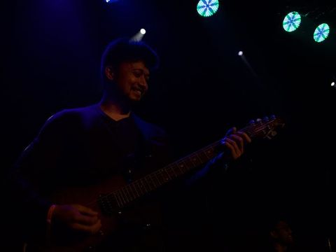 Two singers performing together under stage lights at the fundraising concert.