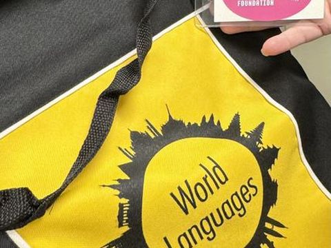 A yellow World Language library bag with a Tender Hearts Foundation sticker attached.
