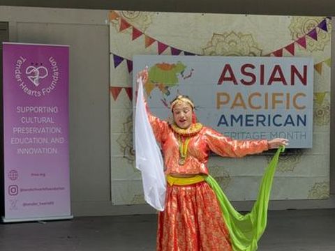 Performers in traditional dress on stage at the AAPI Cultural Festival.