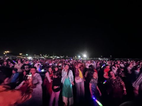 An enormous crowd packed in front of the festival stage after dark.