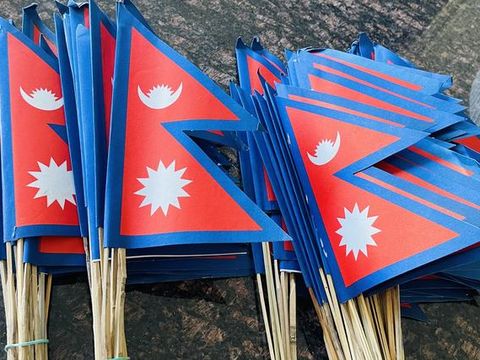 A bundle of more than a hundred Nepal flags on sticks, ready to be handed out.