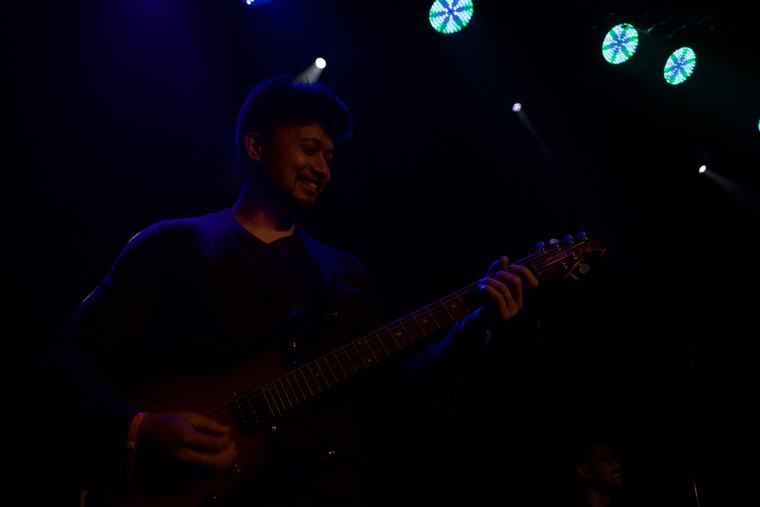 Two singers performing together under stage lights at the fundraising concert.