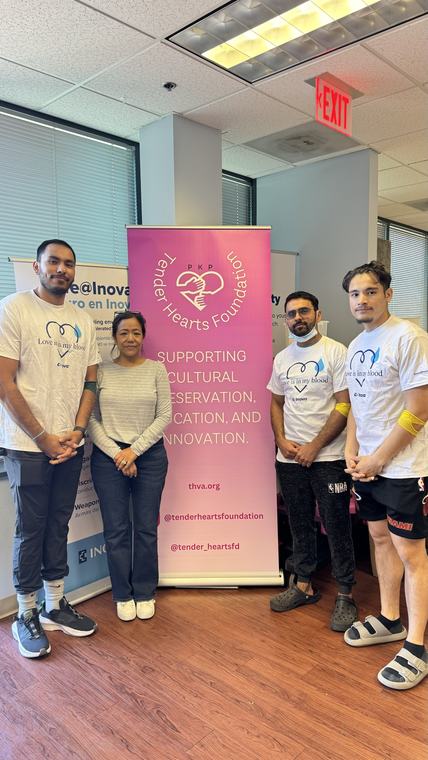 Volunteers in matching shirts standing beside the Tender Hearts banner at the blood drive.