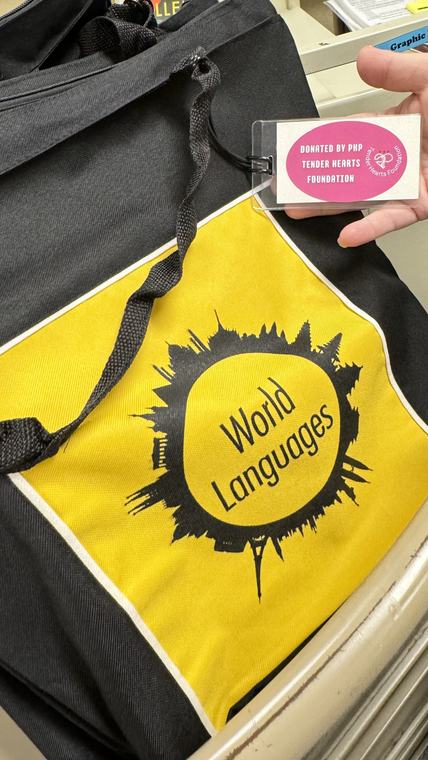 A yellow World Language library bag with a Tender Hearts Foundation sticker attached.
