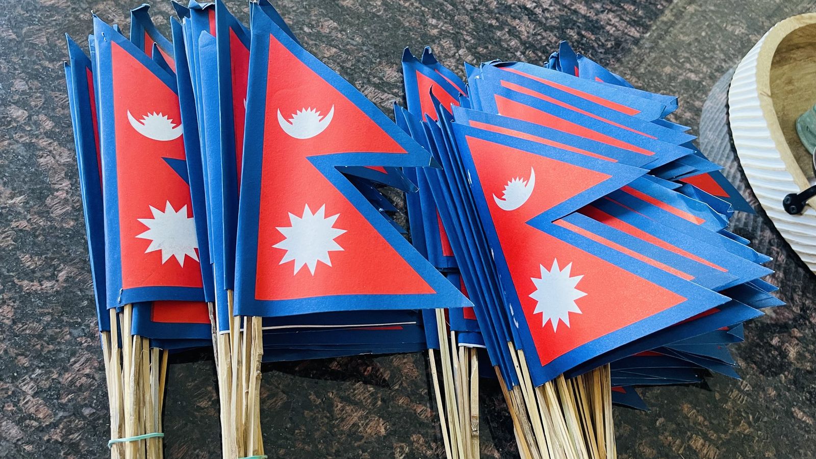 A bundle of more than a hundred Nepal flags on sticks, ready to be handed out.